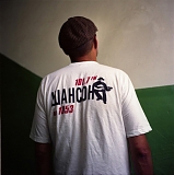 A man poses for picture in a T-shirt with the logo of a local radio station that broadcasts criminal songs - the so-called shanson.