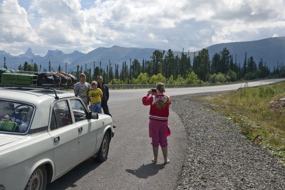 Tourists take a picture during a stop on the M-54 - basically the only road that connects Tuva with the rest of Russia. The rugged Yergak-Targak-Taiga ridge - part of Sayan Mountains - is visible in the background. Before Tuva joined the Soviet Union in 1944, this ridge formed the natural border between the two countries.