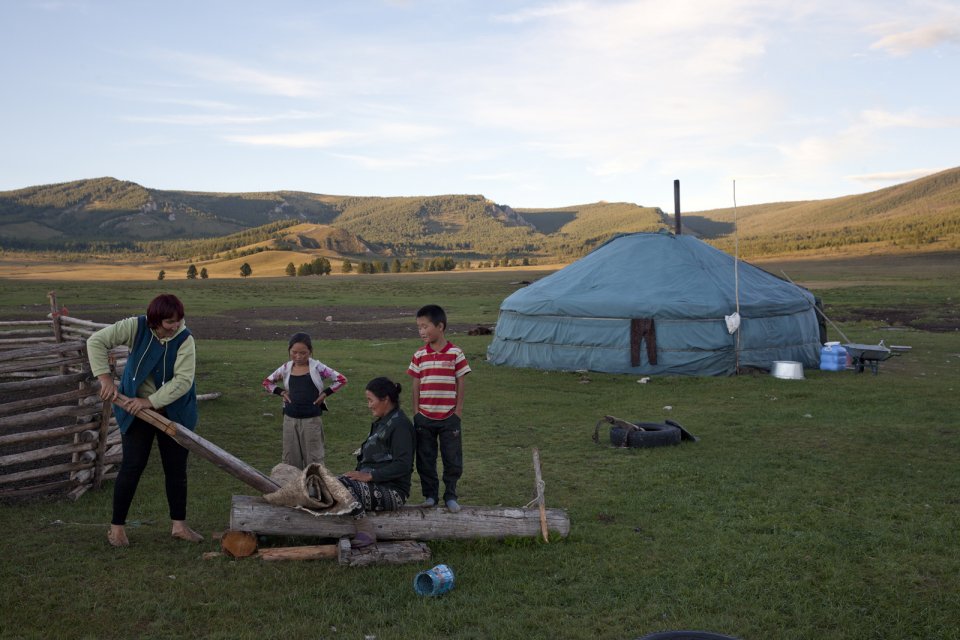 Bayir-Kys Banchyk and Valentina Sambyr demonstrate the traditional way to tan cowhide which is then used to make shoes, as youngsters look on. Such crafts survive only in such isolated communities as this one in Kachyk river valley in southeastern Tuva